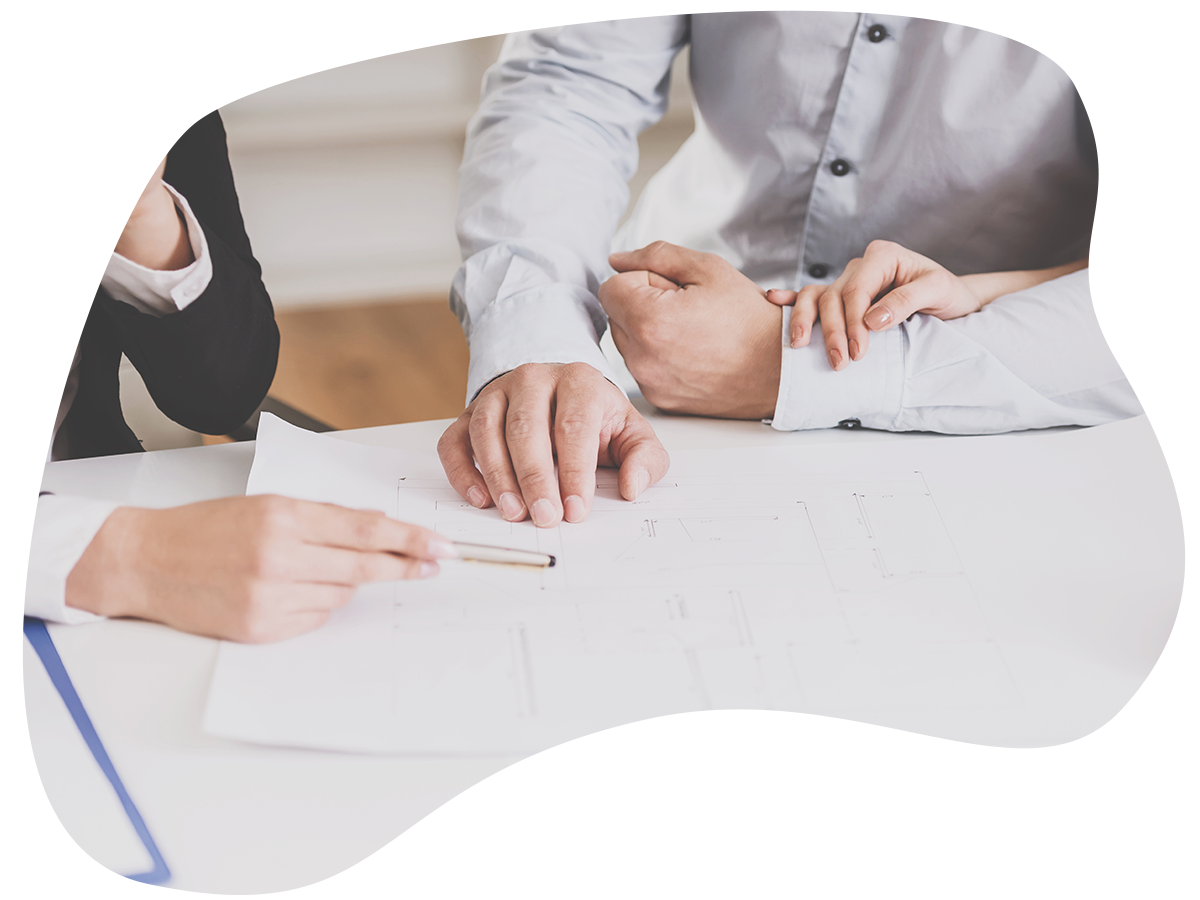 Young realtor showing contract with floor layout in an apartment to a young couple.