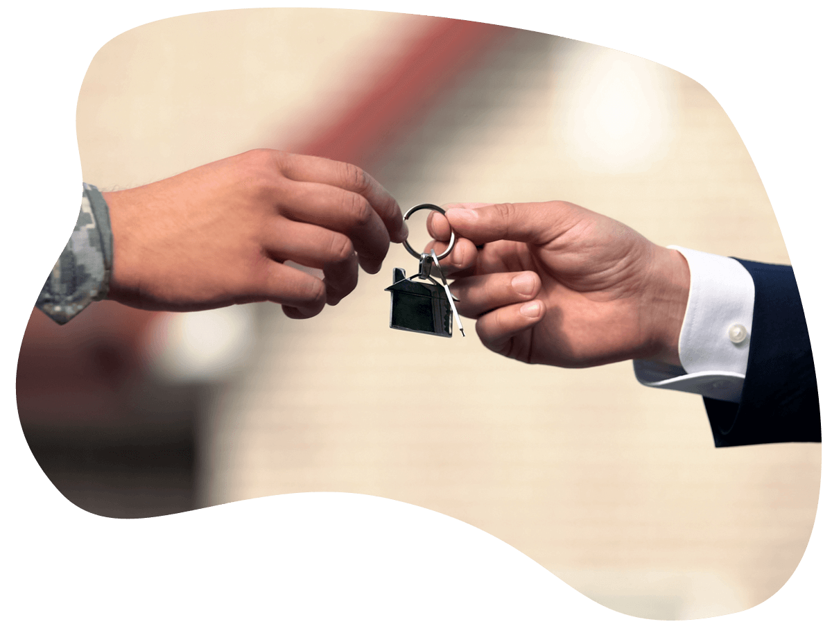 Man in business suit giving house key to man in military uniform